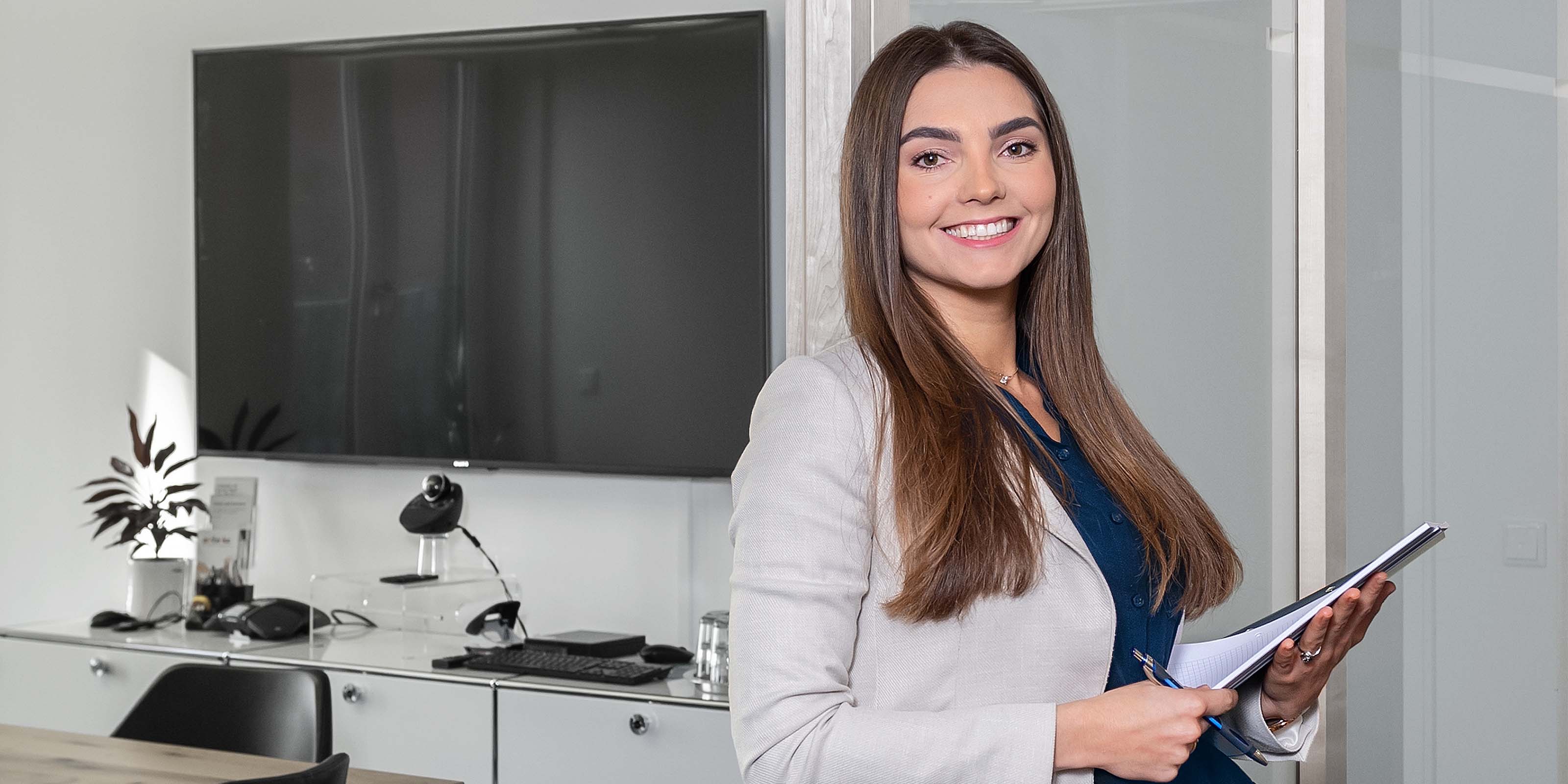 Frau mit Akten in der Hand steht in Kofferenzraum - 