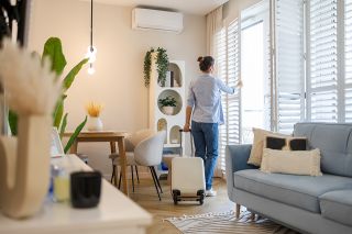 © pikselstock - stock.adobe.com Foto: Frau öffnet Fenster in Wohnung