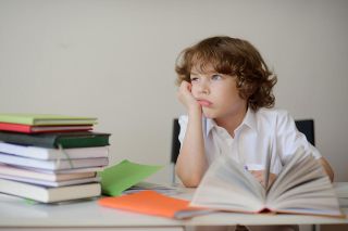 Foto: Junge sitzt am Schreibtisch